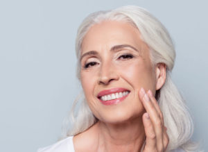 a dental implant patient smiling with her new set of teeth